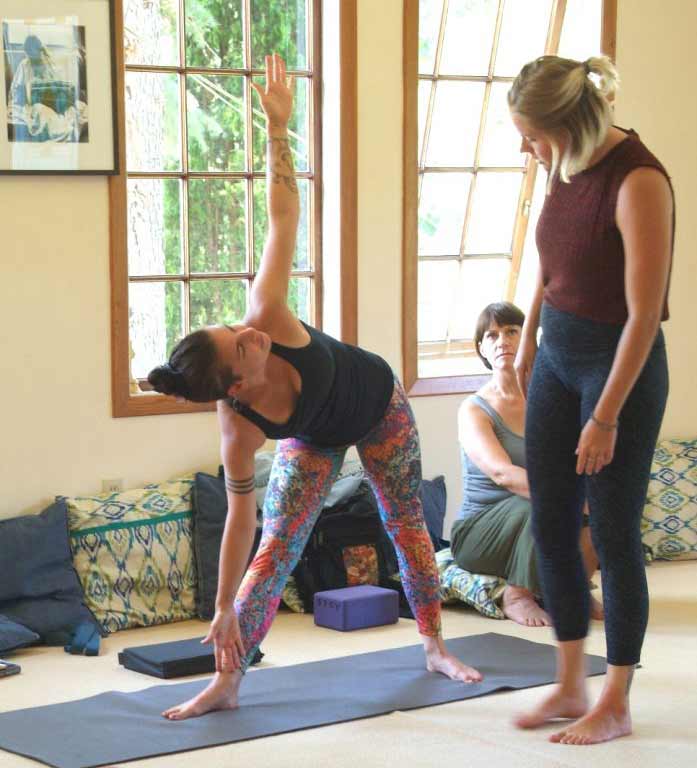 Yogi stretching in a Yoga Teacher Training class