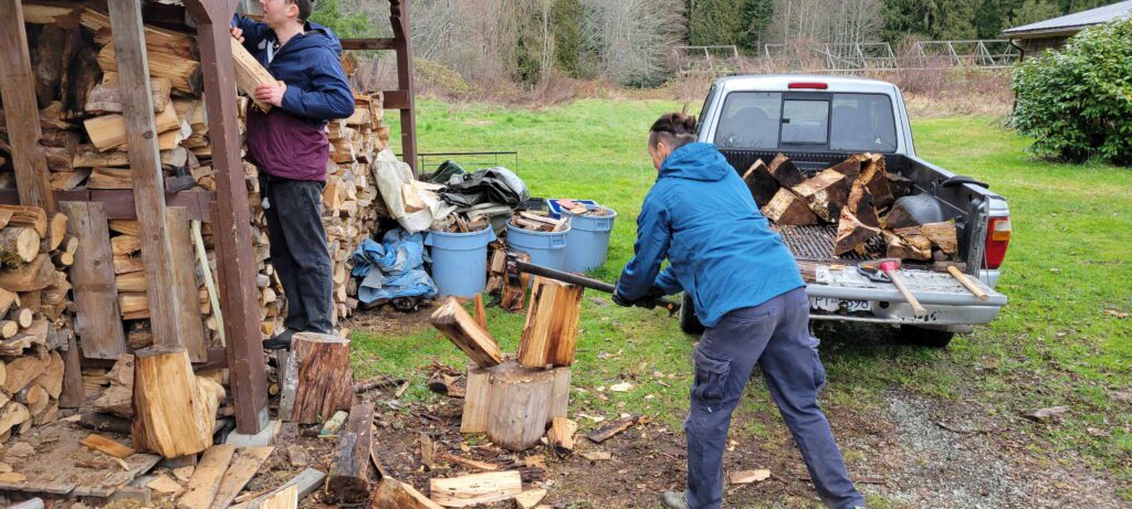 Two karma yogis chopping wood and loading the truck